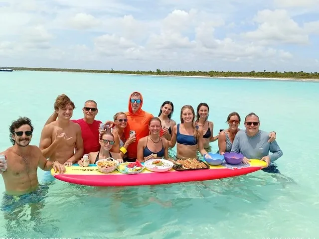 Eine Gruppe von Freunden lächelt für ein Foto mit einem schwimmenden Speisentablett in El Cielo.