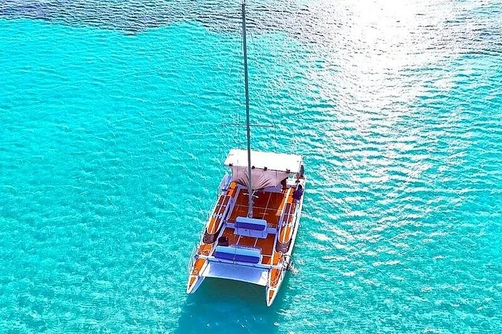 Draufsicht auf einen Katamaran, der in den klaren blauen Gewässern von Cozumel vor Anker liegt.